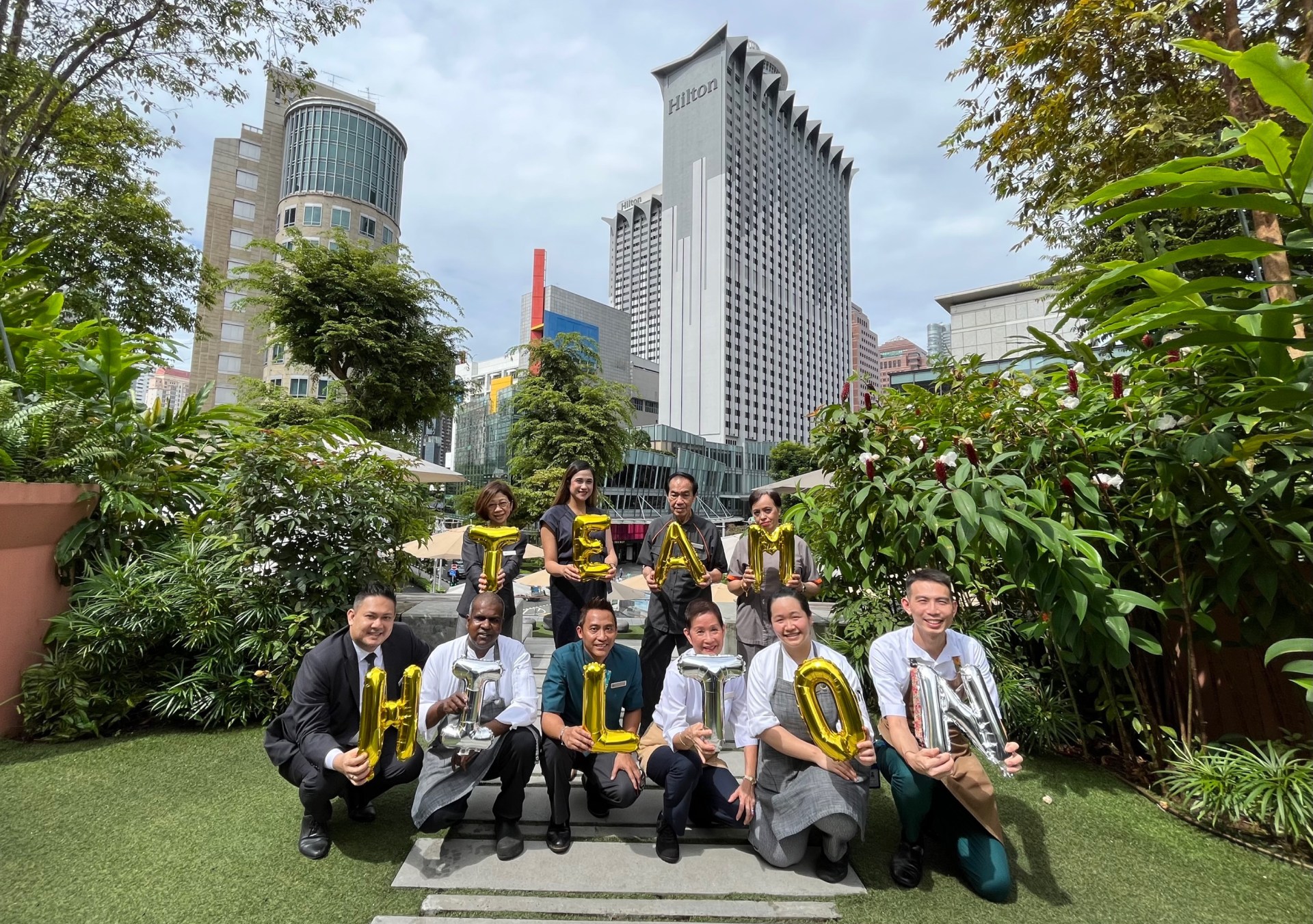 Hilton team members hold "Team Hilton" balloons, Hilton Singapore Orchard