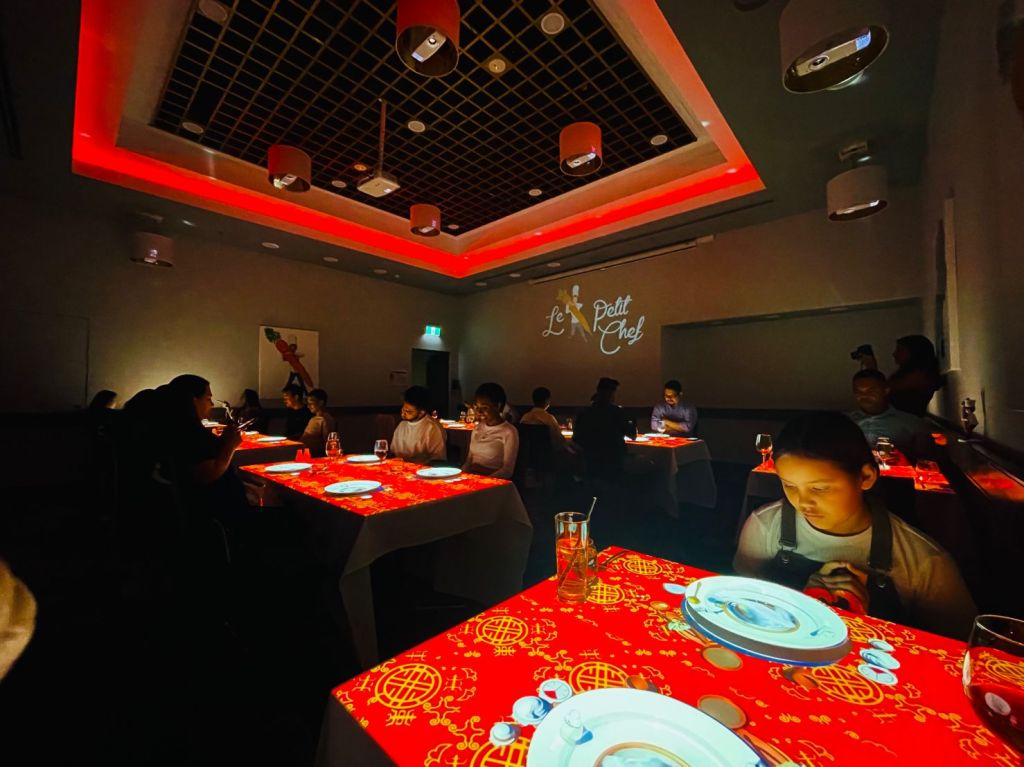 Le Petit Chef at Hilton Darwin - wide shot of room with red tables