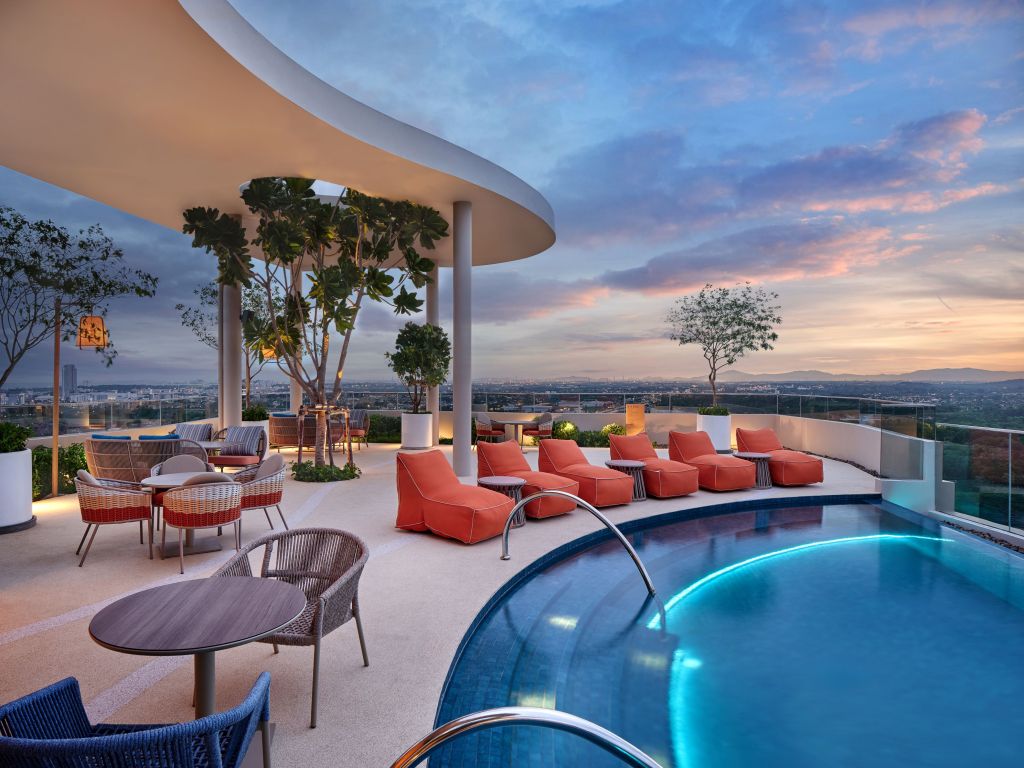 pool surrounded by tables and chairs and seating at Hilton Garden Inn Rayong - Pool