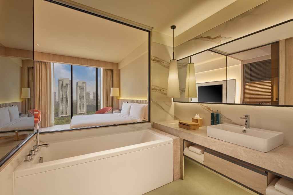 Hilton Gurugram Baani City Centre - City Scape View Bathroom, bathtub, sink, mirror reflecting window