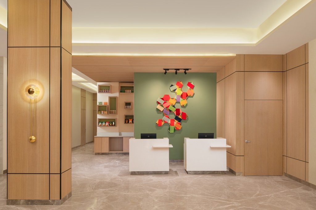 Hilton Garden Inn Surat City Centre, Reception, hanging colorful wall art, sconce light, ceiling spot light fixture, floating shelves