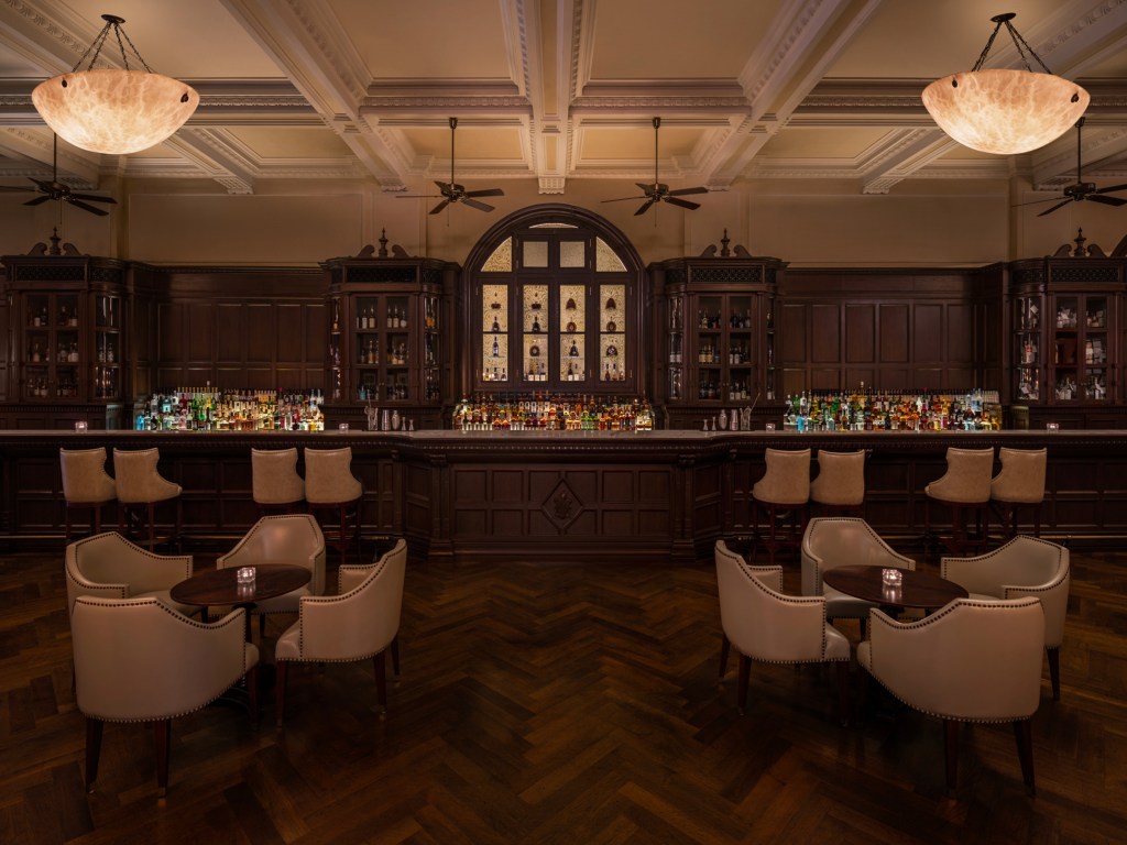 Waldorf Astoria Shanghai on the Bund's Long Bar, bar, ceiling fans, leather seating, bar stools, wooden bar, wood floors, crown molding