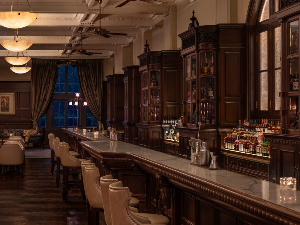 Waldorf Astoria Shanghai on the Bund's Long Bar, bar, marble counter, bar stools, framed artwork, curtains, ceiling fans