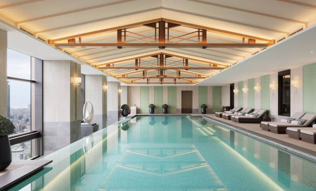 Waldorf Astoria Osaka - Pool, indoor pool overlooking city skyline, lounge chairs and potted plants, ceiling accents
