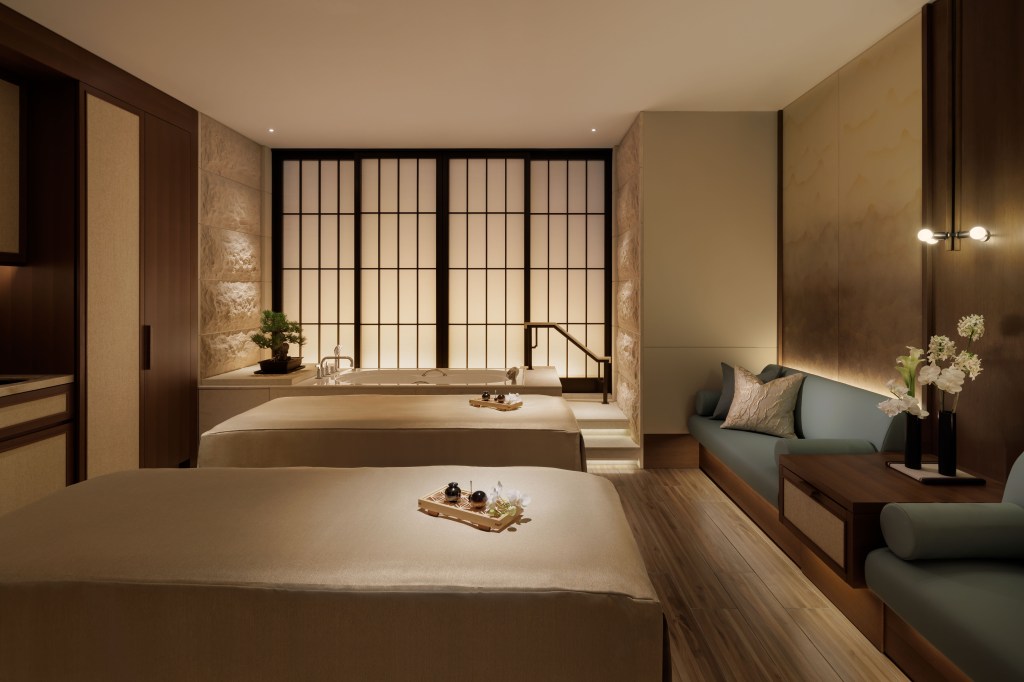 Waldorf Astoria Osaka - Spa, two spa beds side by side with bathtub in the background, blue seating area, flowers