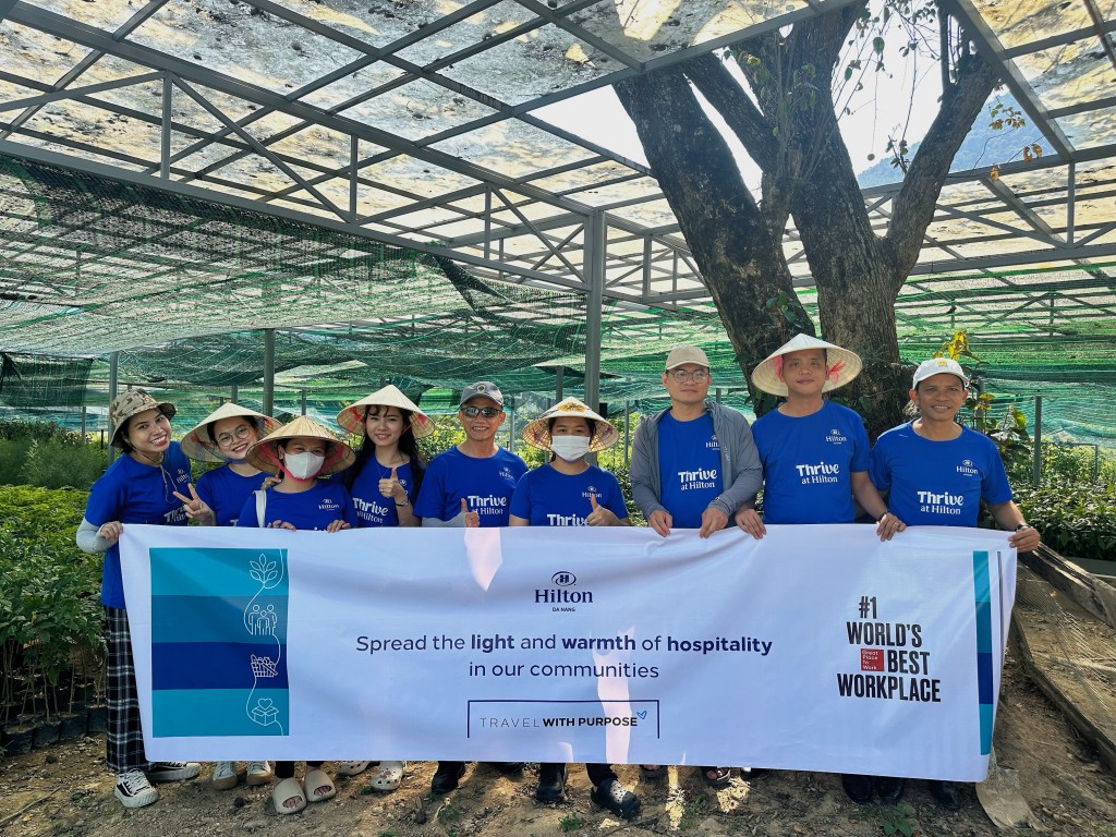 Hilton Named #1 Best Workplace in Vietnam - Hilton Da Nang - small group photo with Travel with Purpose sign