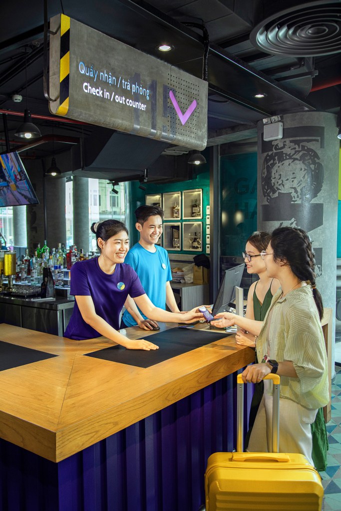 Tru by Hilton Hanoi Station Reception with two team members assisting two guests