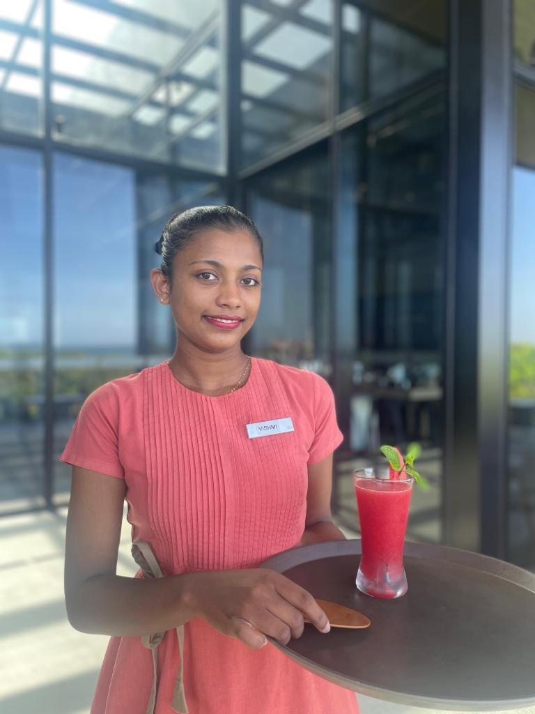 Hilton Team Member Vishmi Prabha holding a tray with a frozen drink on it
