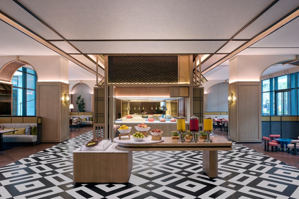 A self serve station in the Autumn Restaurant with drinks and fruit, with various seating options throughout the dining room.