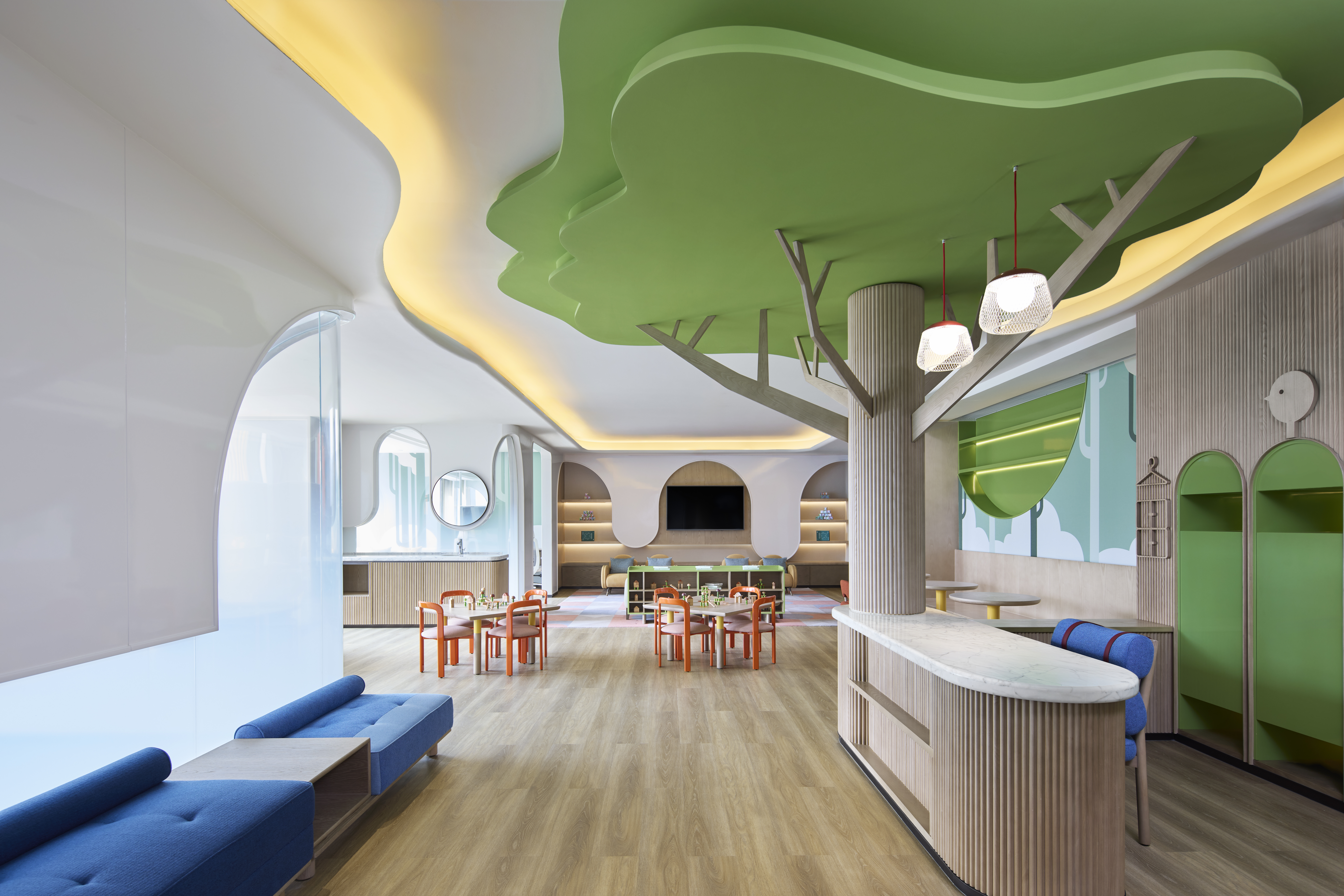 A children's area with prominent wooden tree design at the desk, and children activity tables