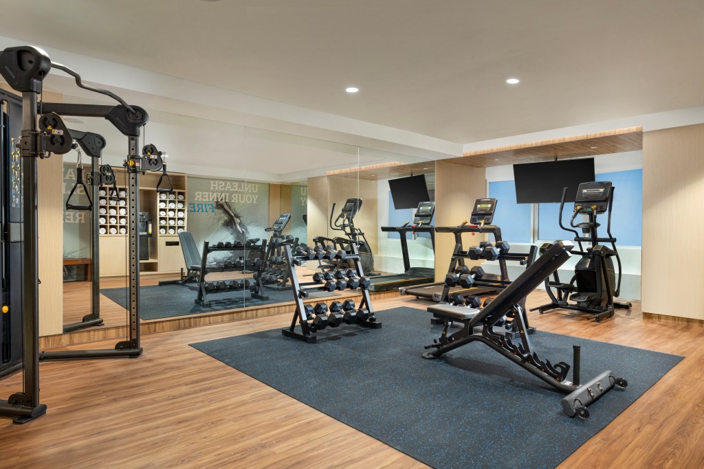 Gym equipment including free weights, treadmill, and elliptical