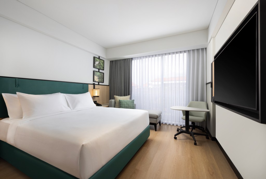 A room at the Hilton Garden Inn Bali Nusa Dua with king bed, tv, and seating area.
