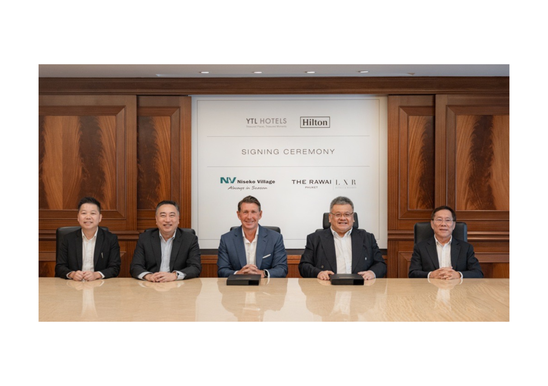 A group of YTL Hotels and Hilton leaders smiling at camera