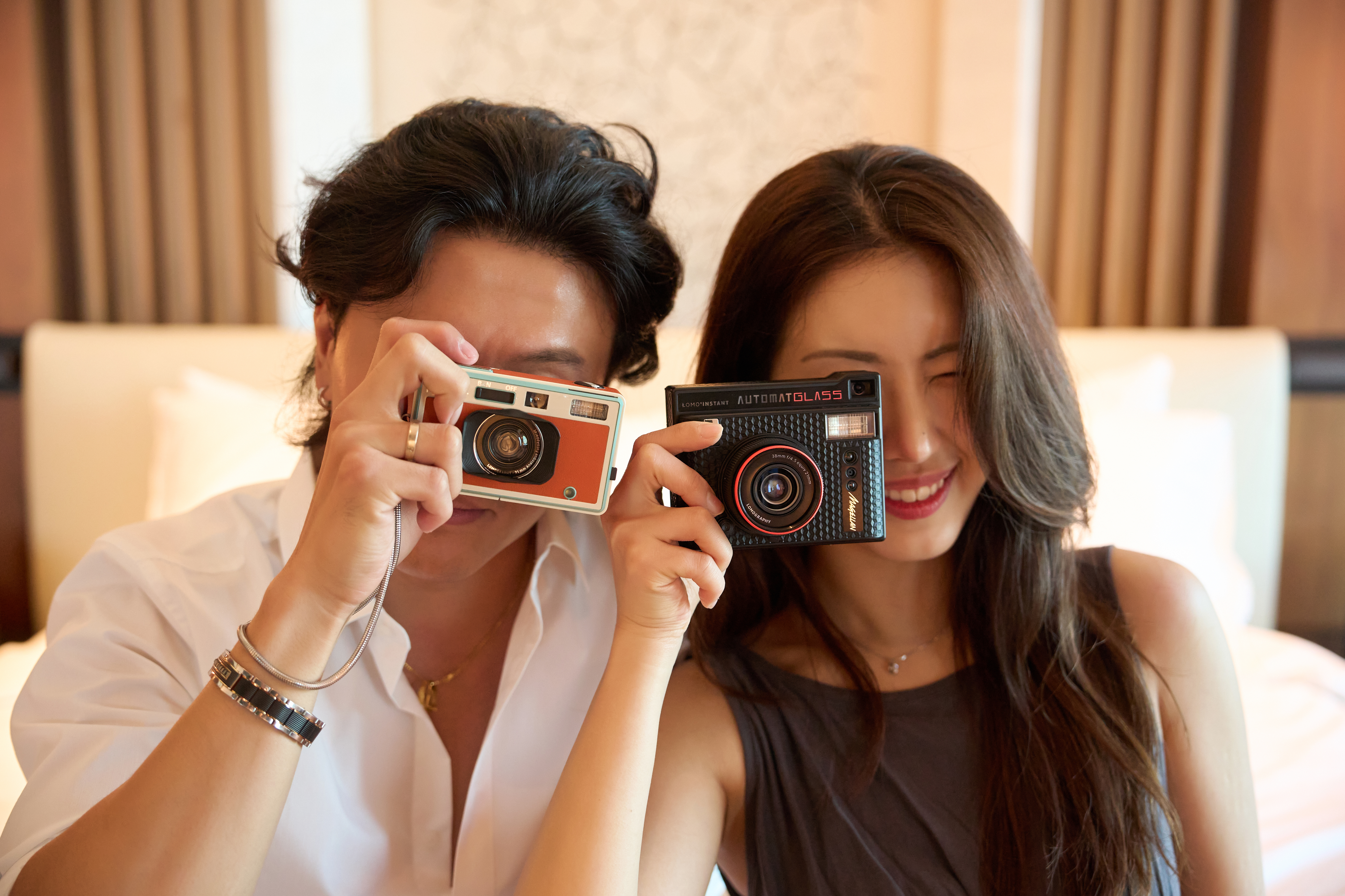 A couple taking photos looking at camera