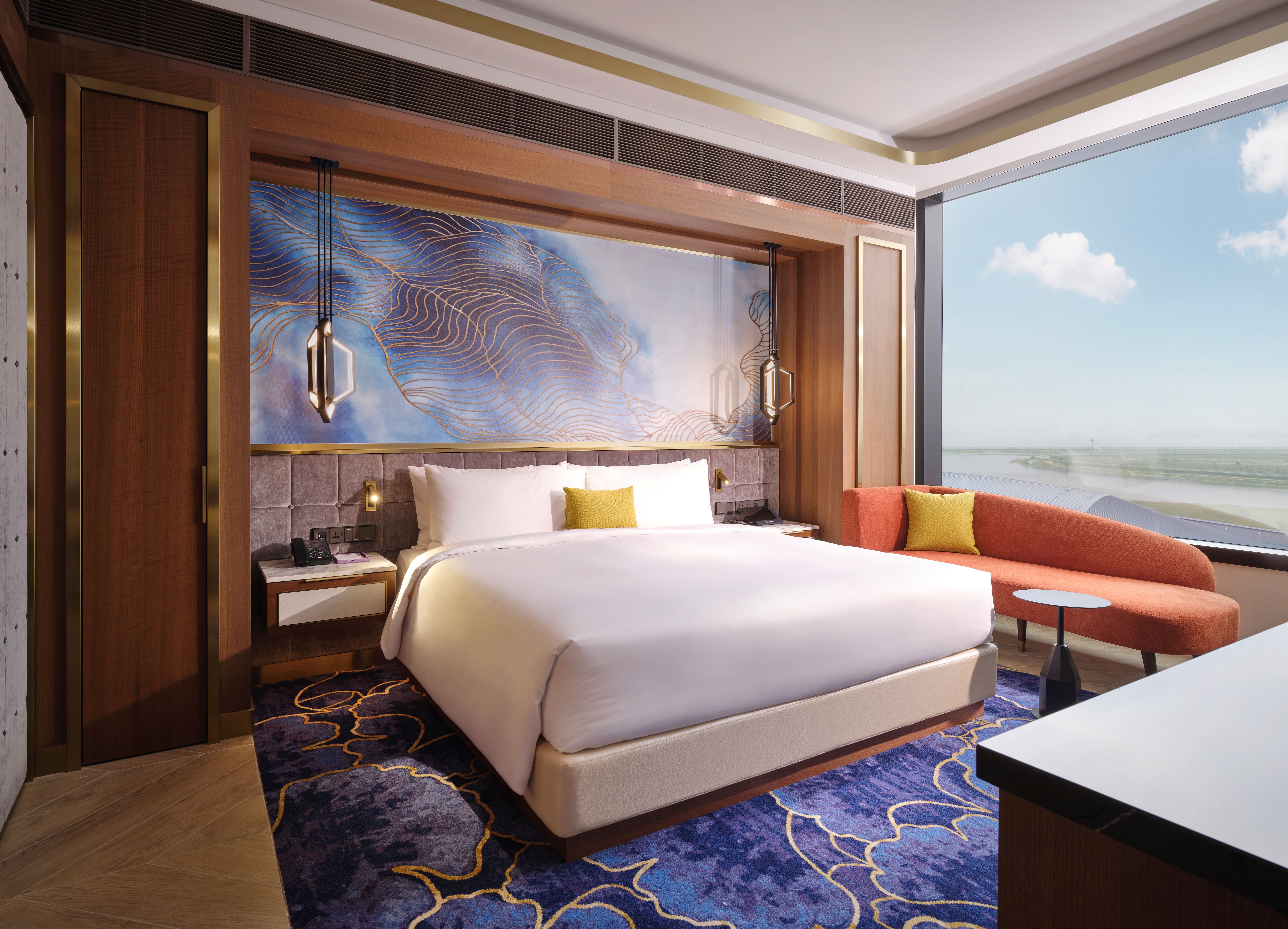 Hotel suite with bed, couch, and large window