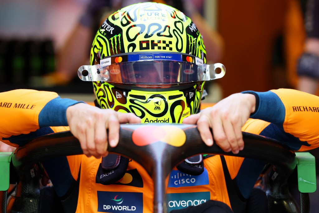 Lando Norris sitting down into his Formula 1 car