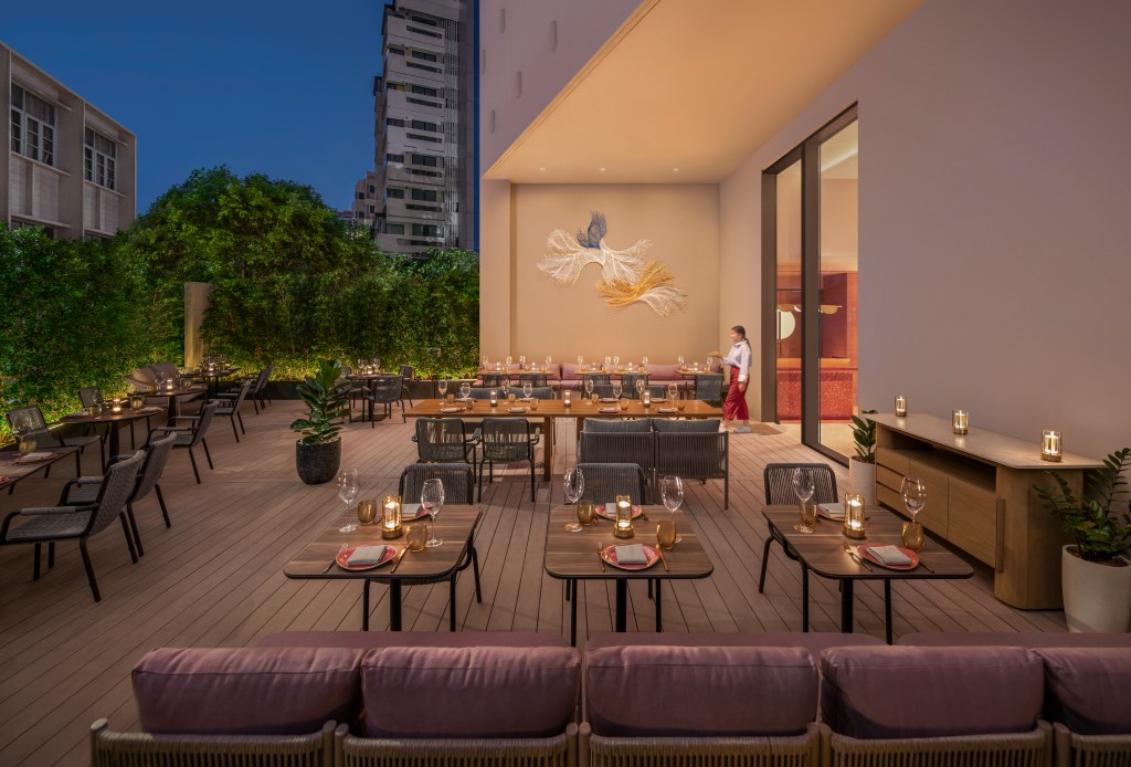 An outdoor dining space with many candle lit tables