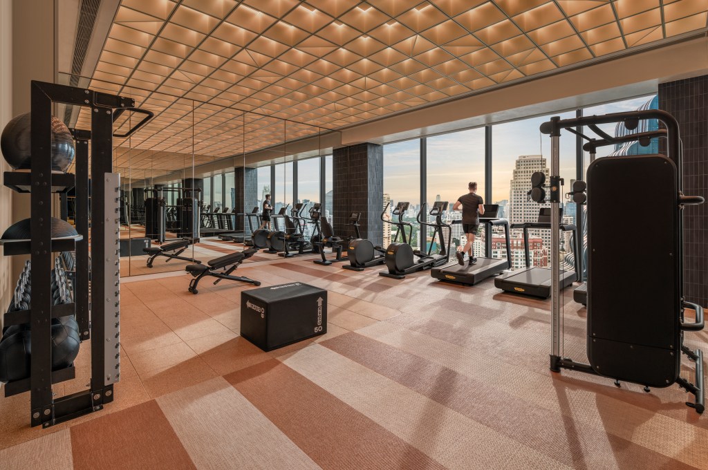 A gym with various equipment including treadmills, stationary bike, and free weights