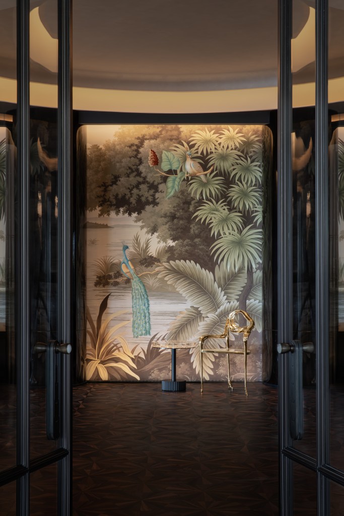 The entrance to the room, framed by doors, with a peacock mural on the wall.
