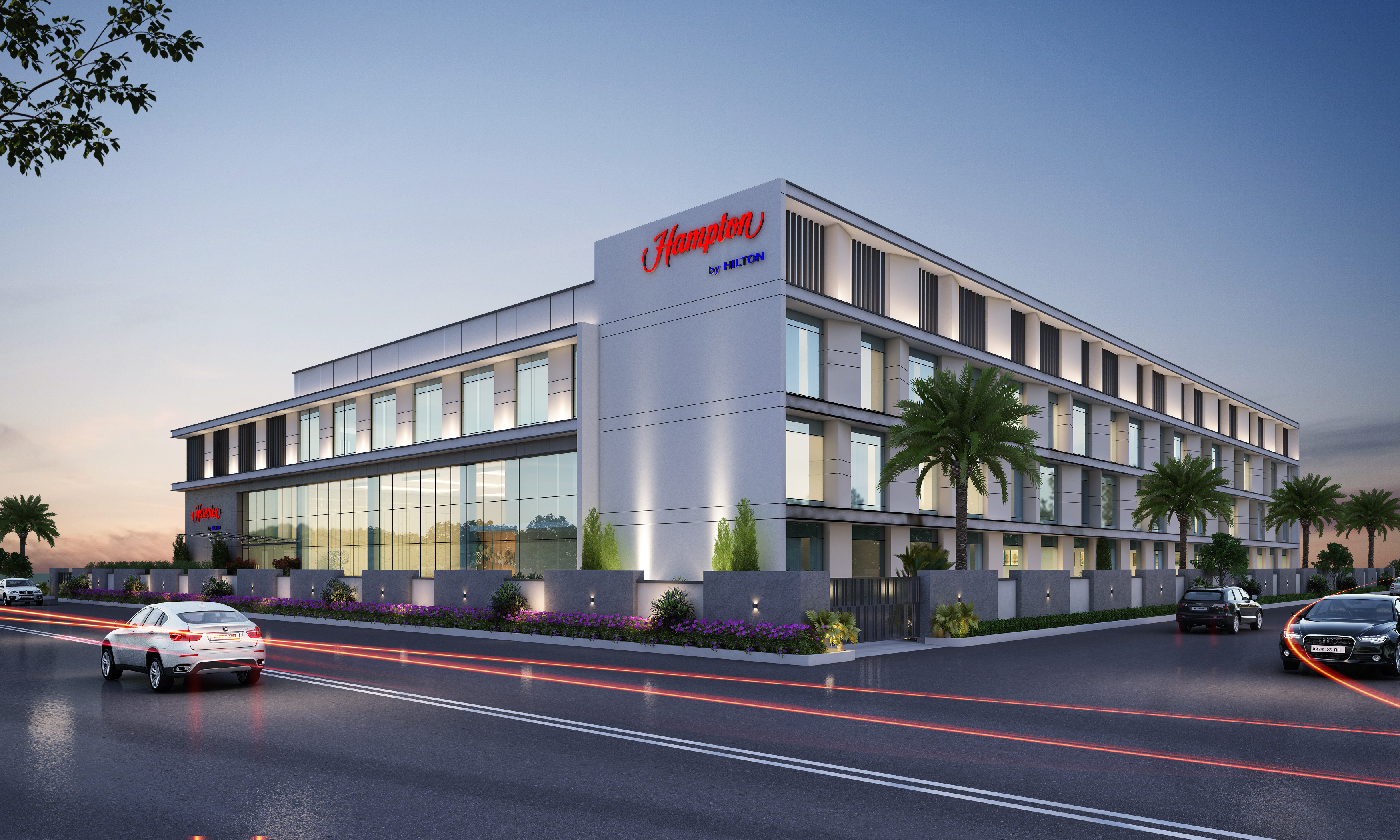 The exterior of the hotel with cars driving by