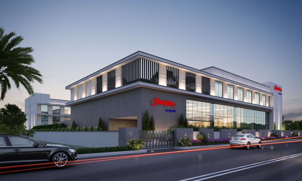 The exterior of the hotel with cars driving by