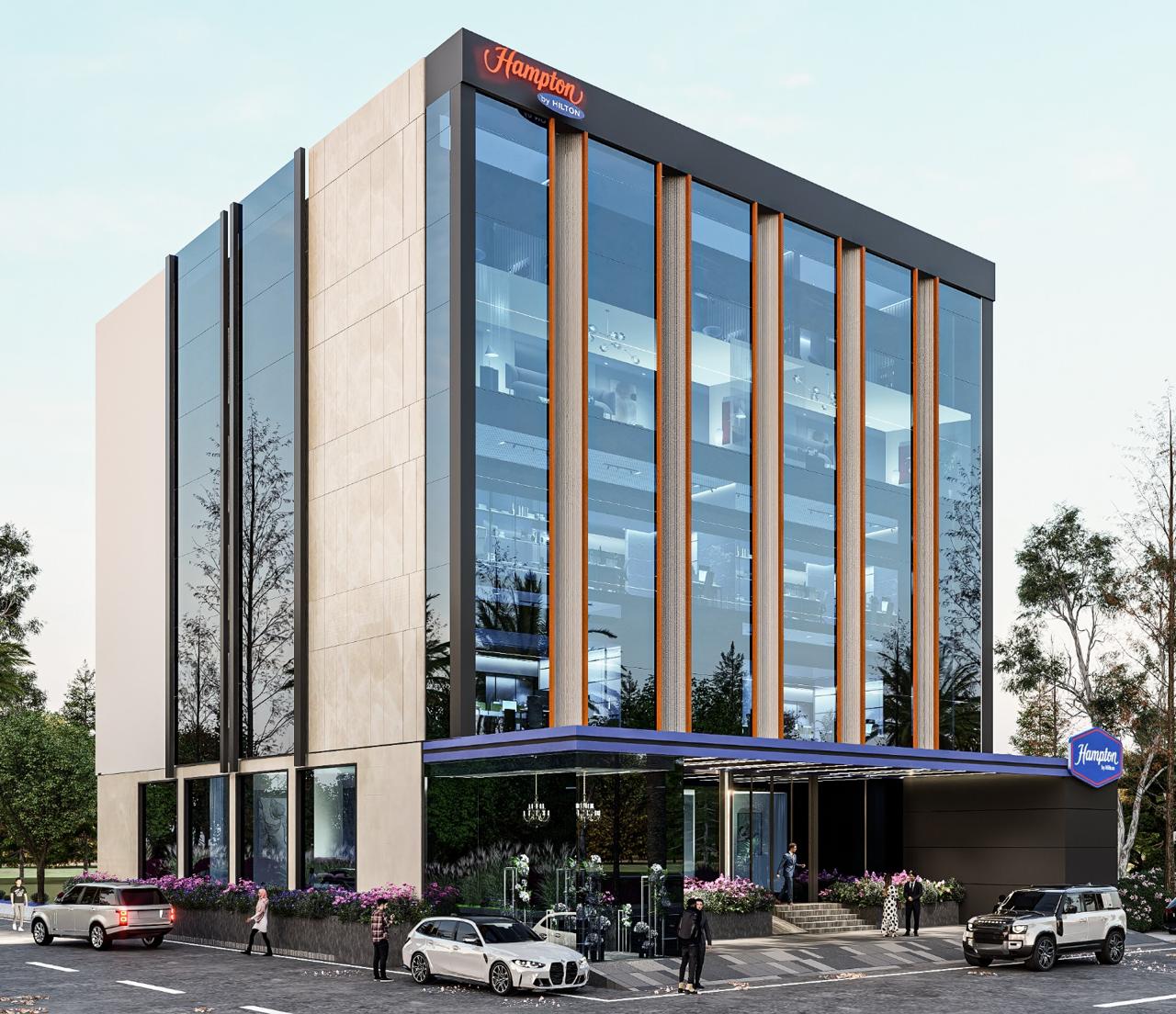 The exterior of the hotel with cars driving by