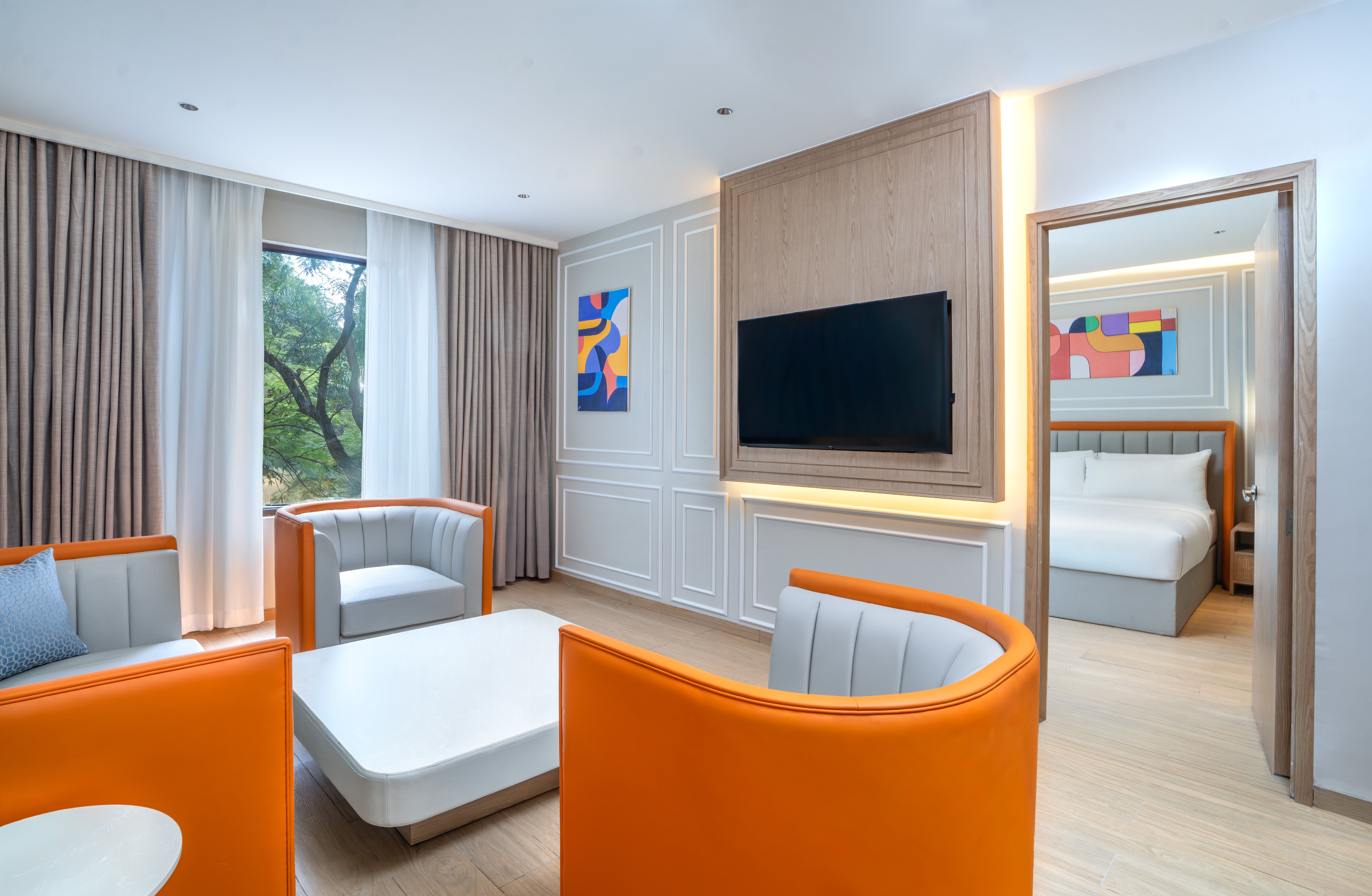 The seating area in a living room, with bedroom in background.