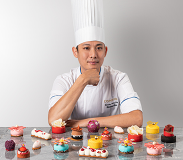 Richard Chew sitting with many pastries