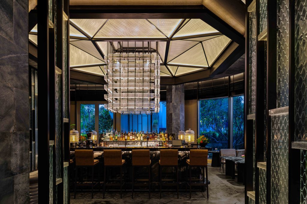 Looking through doors to the bar with chandelier above and windows behind