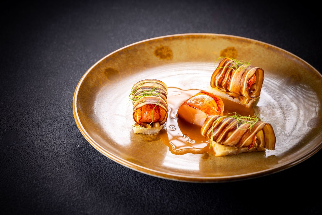 Three blue lobster rolls on a plate