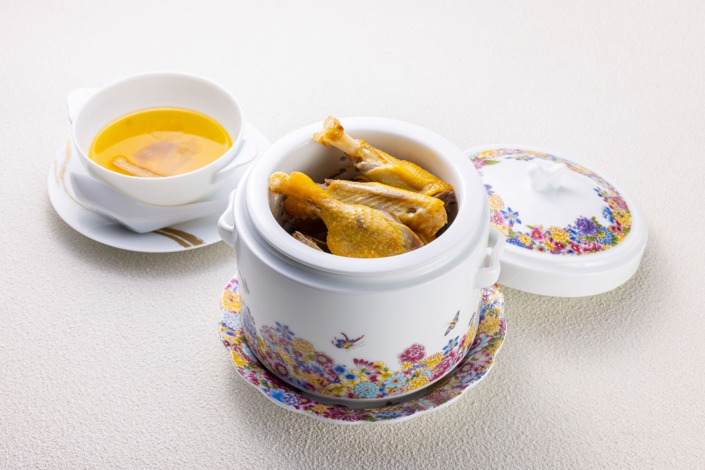 Duck in a china serving crock, with broth beside