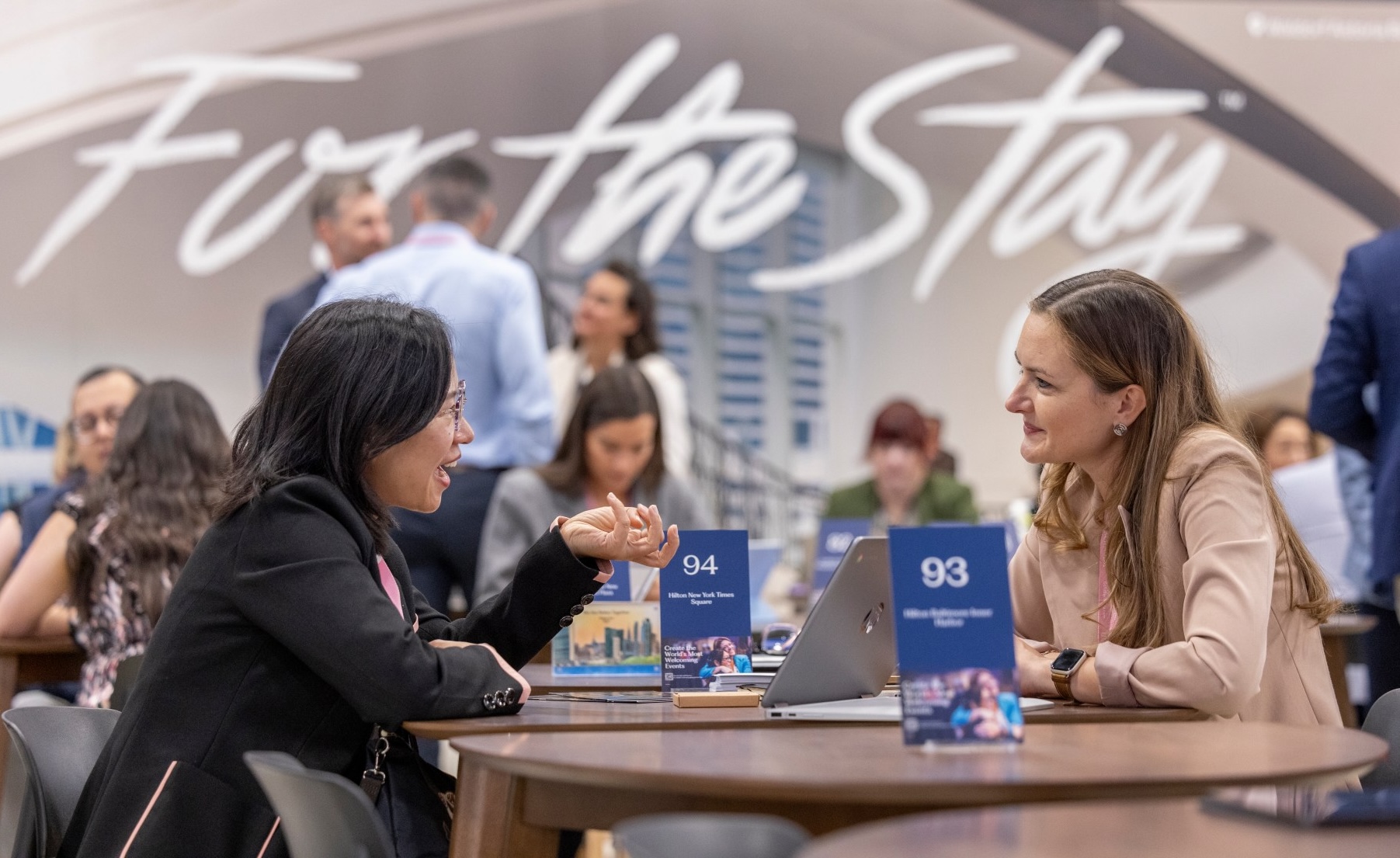 Two people sitting at table networking at an event