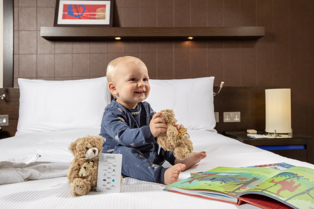 baby on bed in hotel room