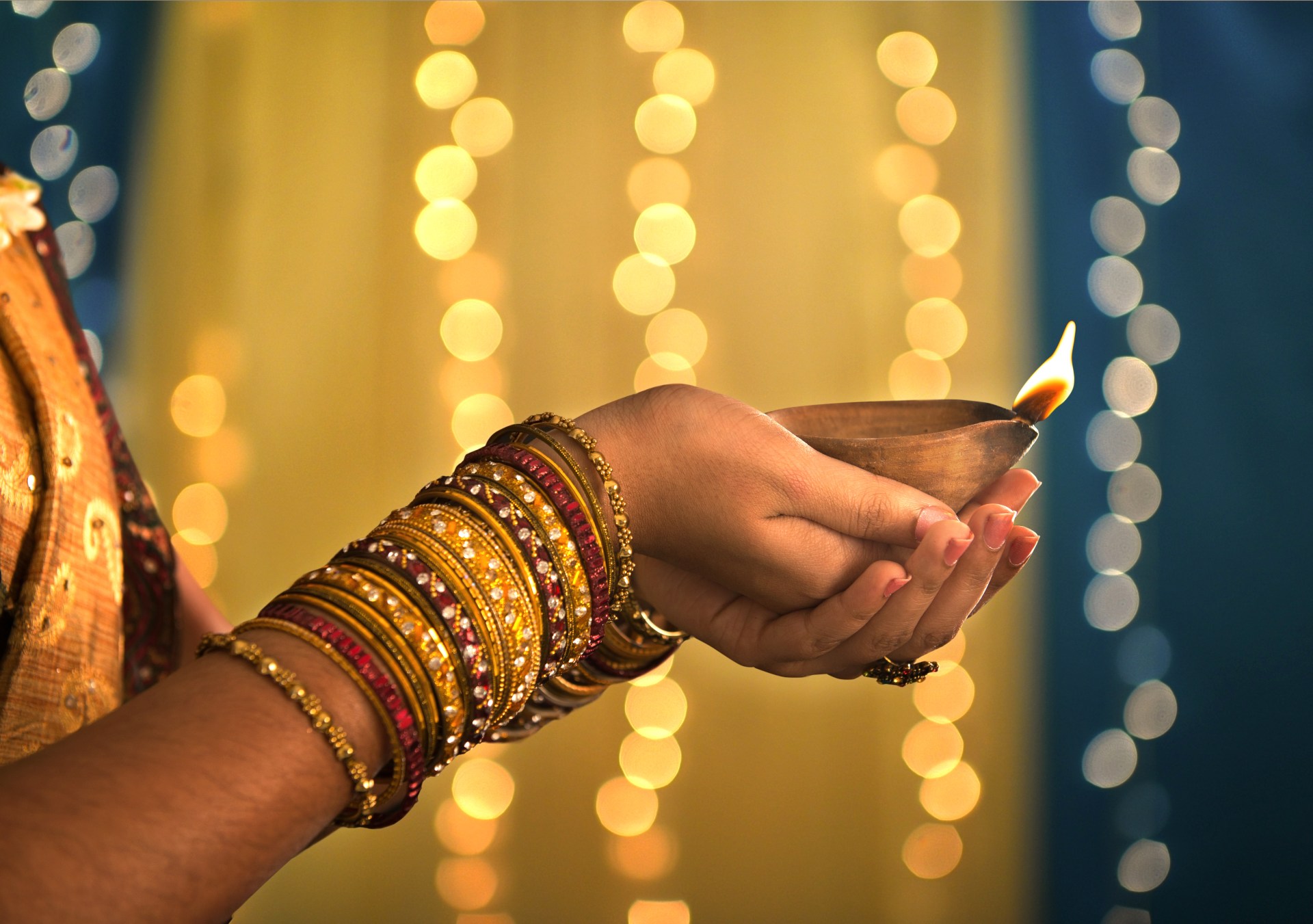 Diwali Festival of Lights, Hands holding oil lamp. Photo Credit: wong yu liang/Shutterstock