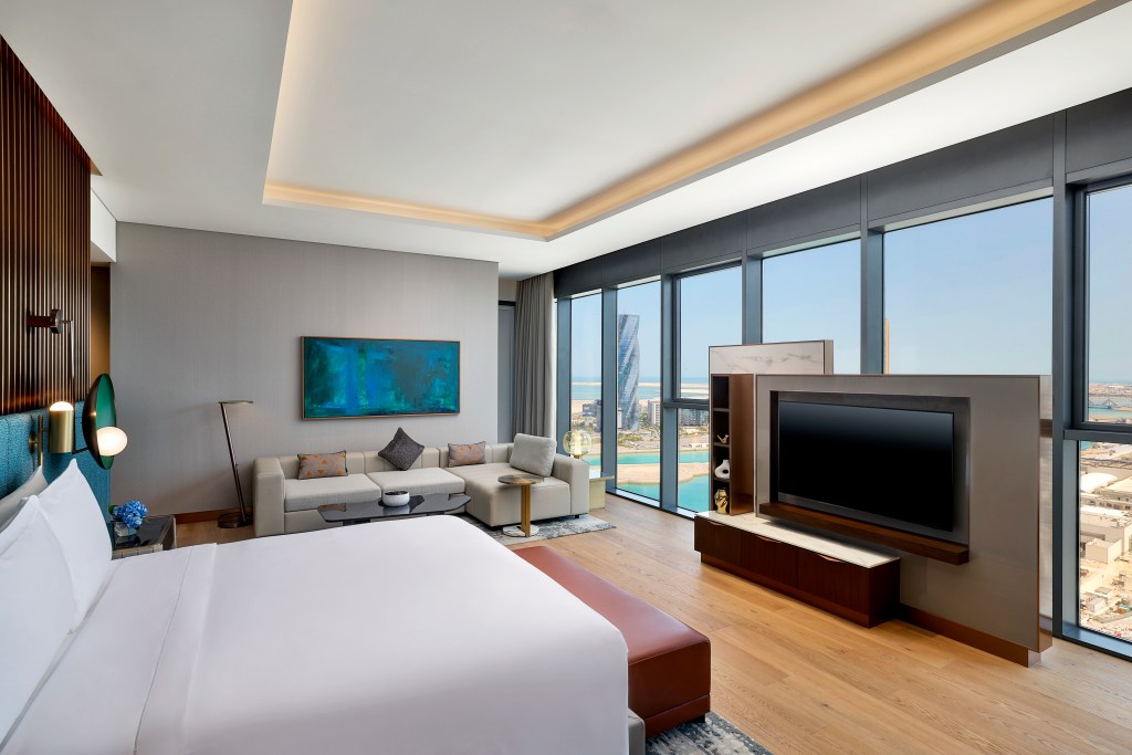 Conrad Bahrain Financial Harbour - King One Bedroom Residential Suite with Balcony - bed, television, seating area and large windows
