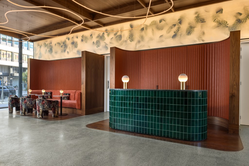 green tiled reception desk and colorful lobby seating at DUO Hotel Lisbon, Curio Collection by Hilton