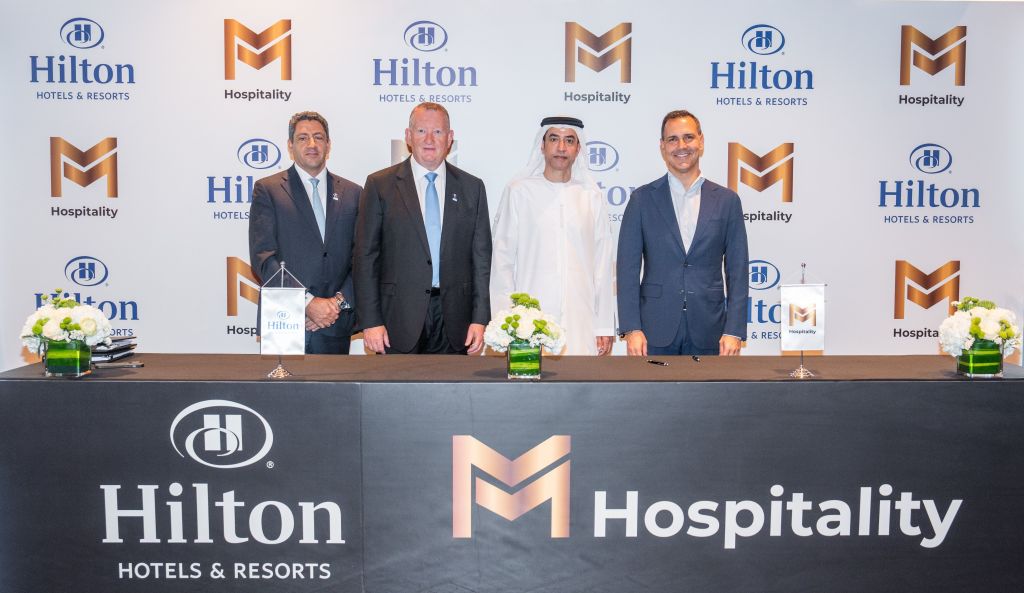 Signing Ceremony - Hilton Marjan Island Beach Resort &amp; Spa four men at a table