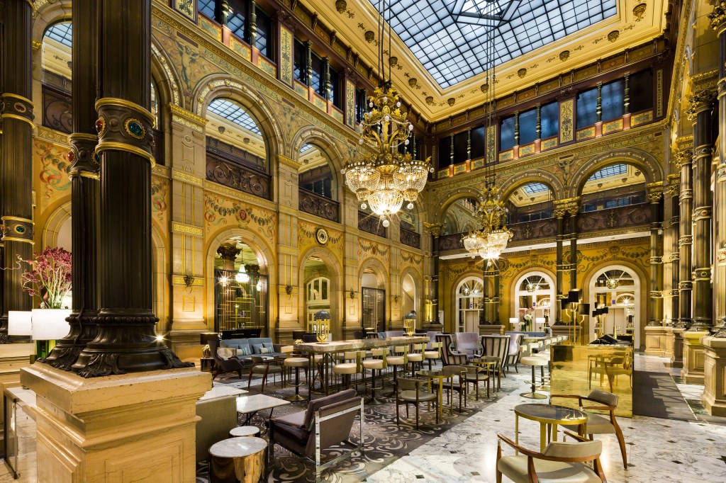 Hilton Paris Opera Le Grand Salon, gold decor, chandeliers, tables and chairs, columns with jewel embellishments