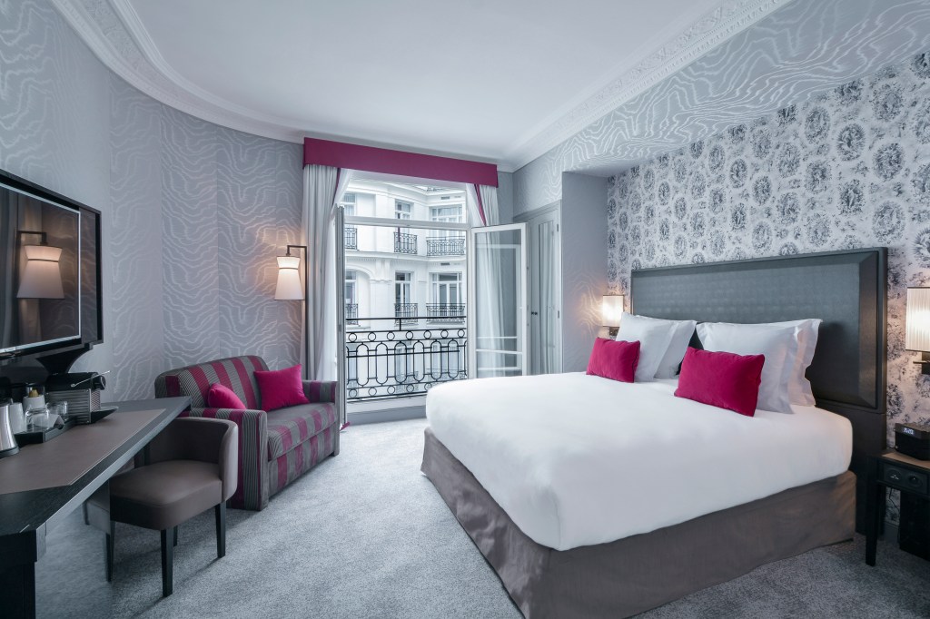 Maison-Astor-Paris-Curio-Collection-by-Hilton-Guest-Room, pink, grey and while decor, pink and grey chair, bed, tv, desk chair balcony