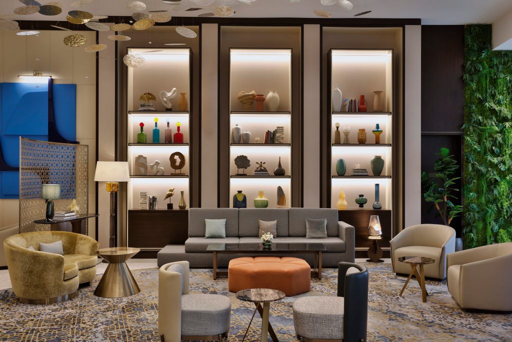 Embassy Suites by Hilton Dubai Business Bay - Lobby with several seating areas, and a large focal wall with art