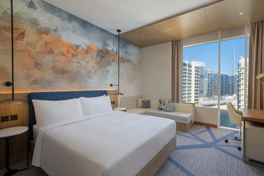 Embassy Suites by Hilton Dubai Business Bay - Room - white bed, orange and blue wall mural, large window