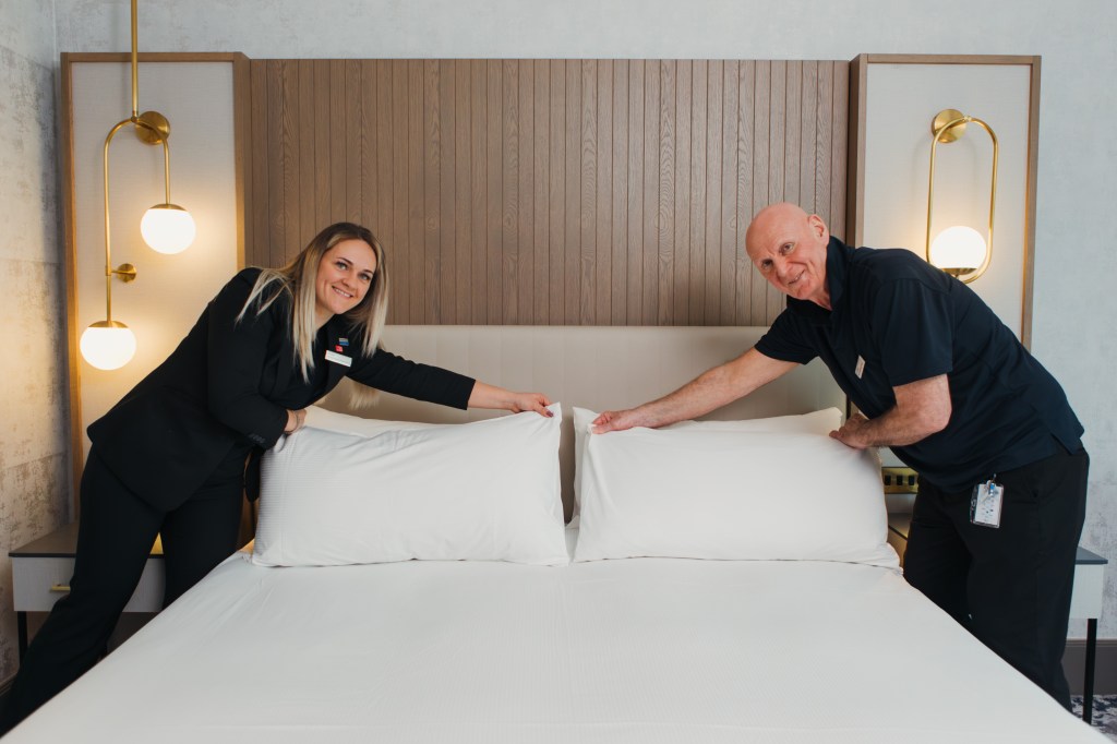 Hilton team members, Man and woman making the bed