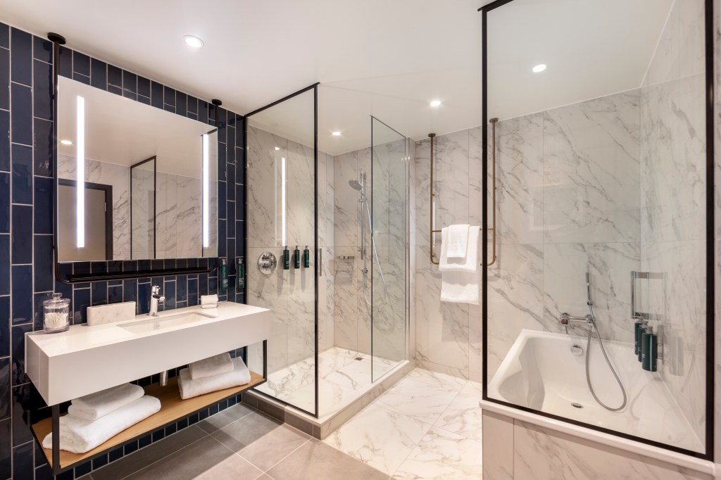 Hilton Woking - Junior Suite Bathroom, mirror, sink, undersink towel storage, separate shower and bathtub