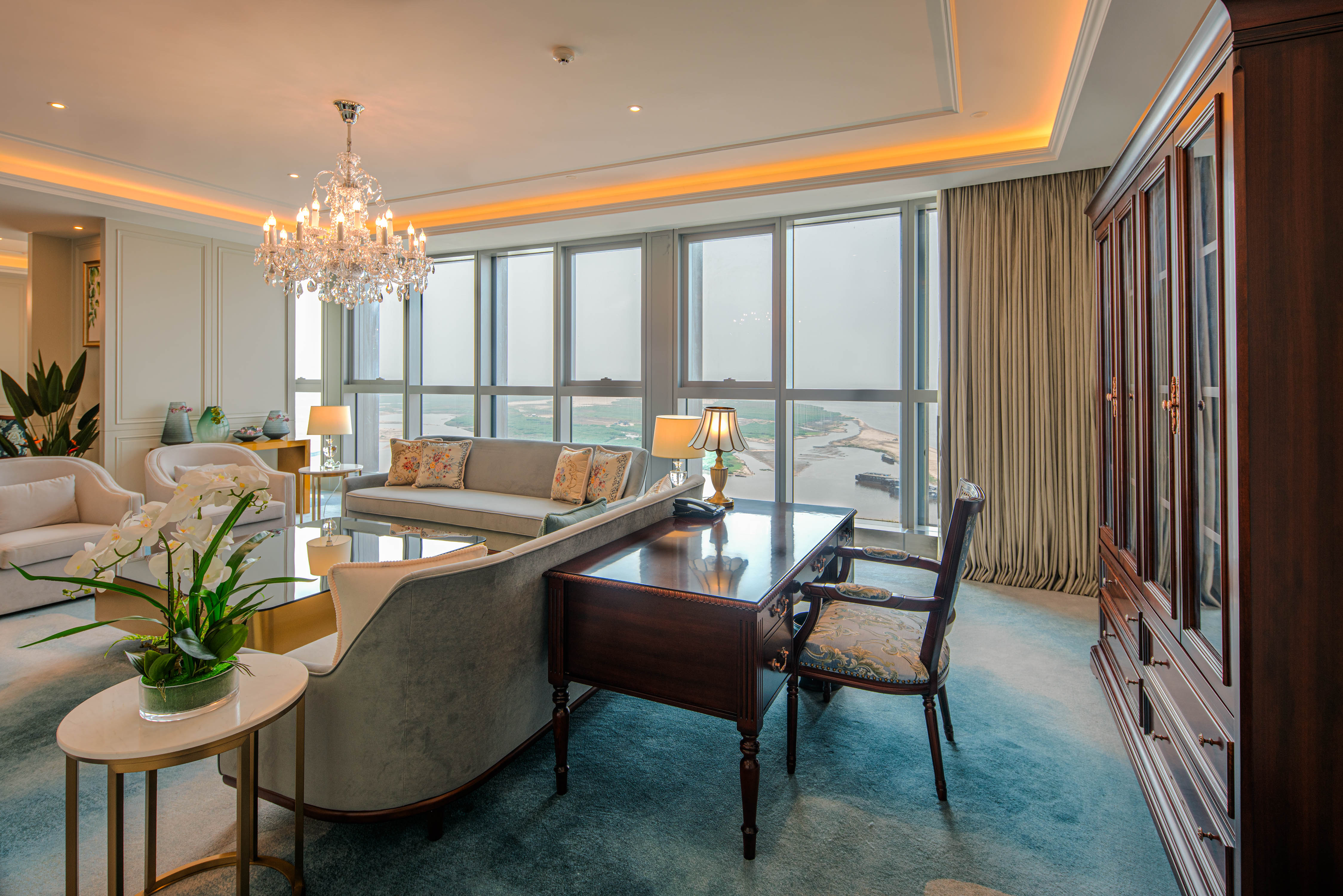 Hilton Brazzaville Les Tours Jumelles Hotel &amp; Residences, Diplomatic Suite, seating area, chandelier, desk, phone, lamp, orchid, gold coffee table, floral throw pillow, table lamp