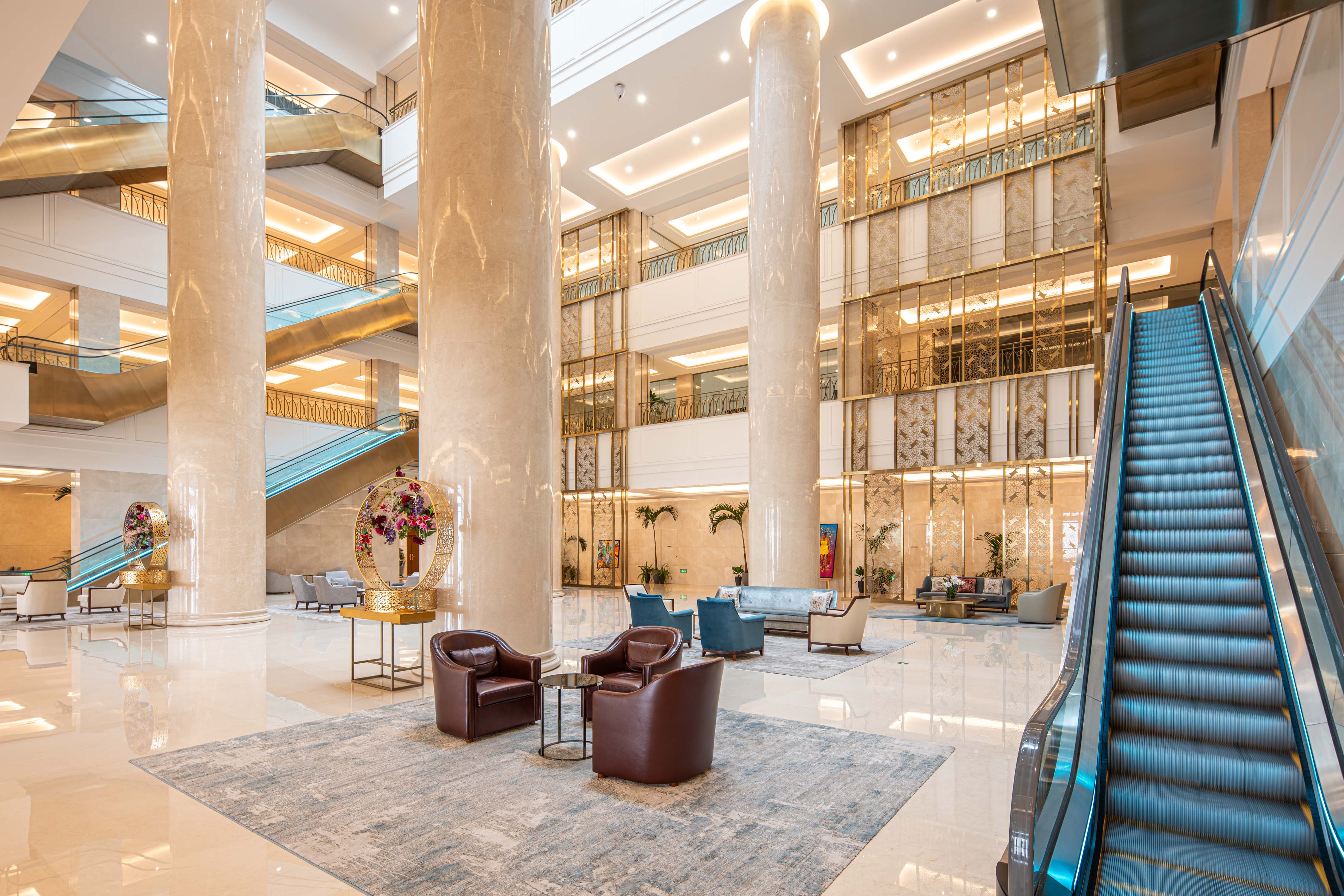 Hilton Brazzaville Les Tours Jumelles Hotel &amp; Residences, Lobby, seating area, marble columns, floral arrangement, escalator, leather seats