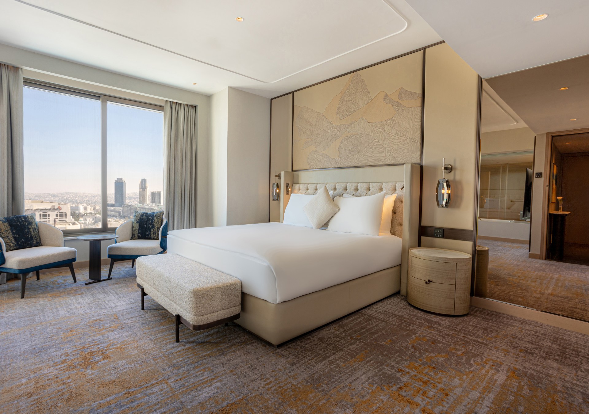Signia by Hilton Amman - Bedroom, bed, large mirror, side table, chairs and table