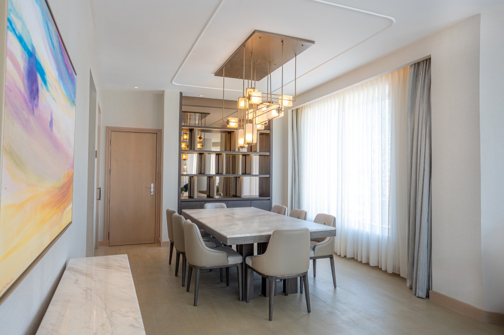 Signia by Hilton Amman - Dining Room with tale and chairs and stylish storage area