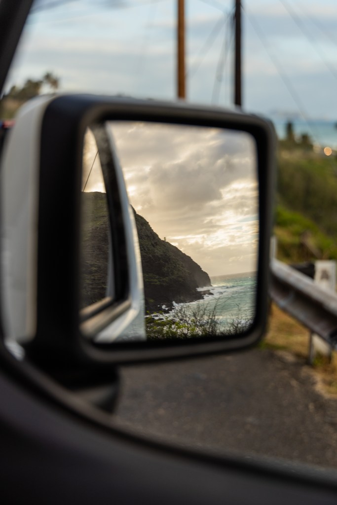 looking out of a car window at a rearview mirror with mountains and ocean reflected - Ka La’i Waikiki Beach, LXR Hotels &amp; Resorts - Adventure