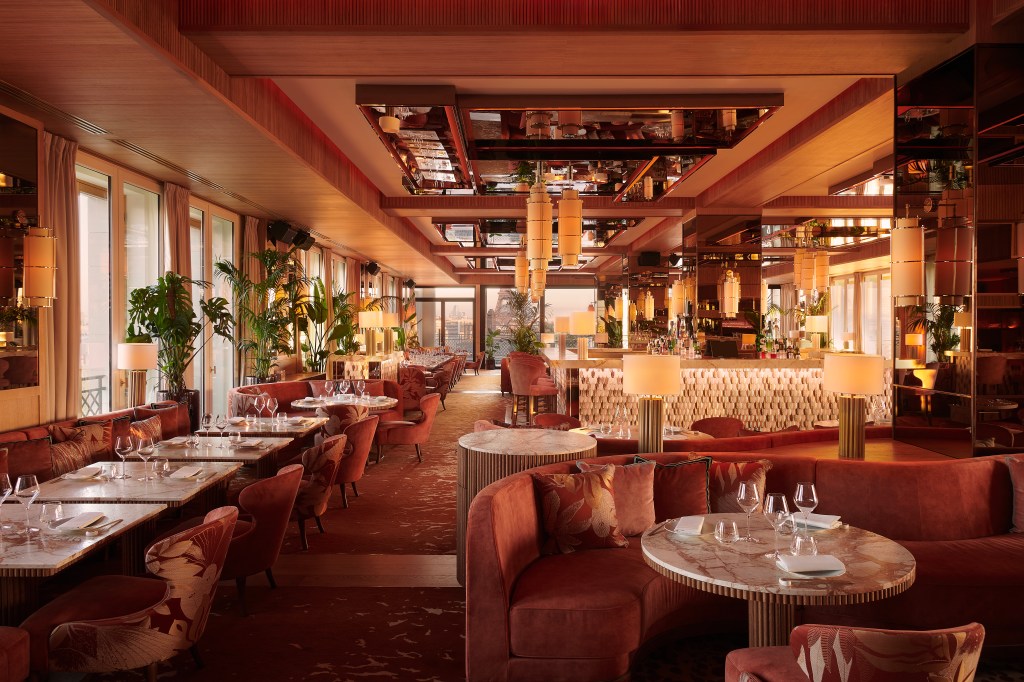 Sax Paris, LXR Hotels & Resorts - Kinugawa Rive Gauche Rive Gauche Restaurant Day- Credit - Claire Israel, dining area with red tables, booths and chairs, bar area in the background