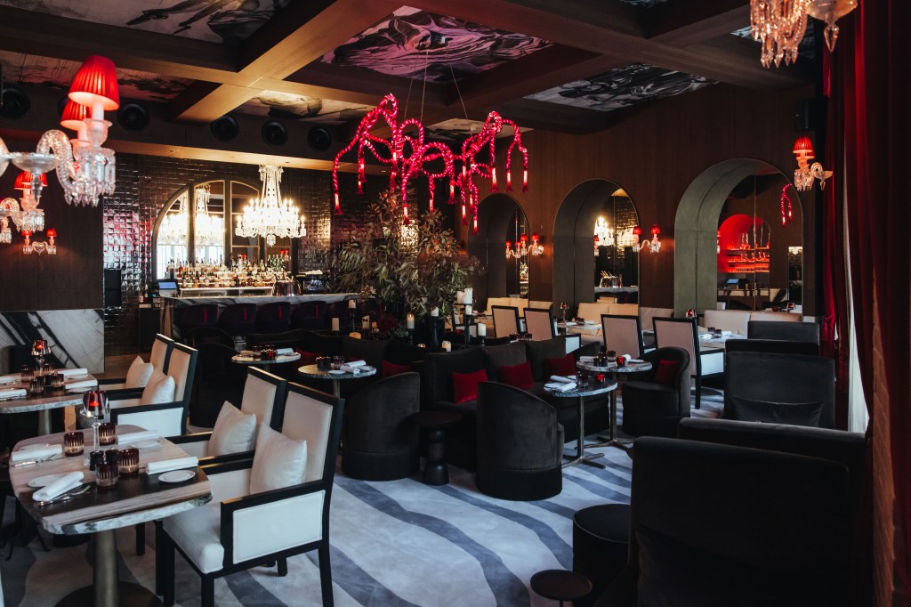 Sax Paris, LXR Hotels & Resorts - Restaurant Le SAX, black white and red decor - tables, chairs, decorative light fixtures and zebra striped carpeted dining area